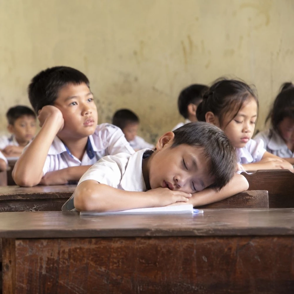 Học sinh mệt mỏi, thiếu tập trung, ngủ gật trong lớp vì thiếu dinh dưỡng. (Ảnh được tạo bởi AI)