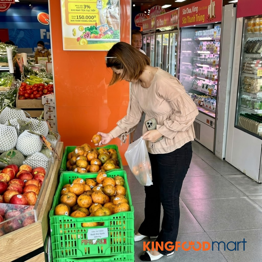 Kệ trái cây tươi tại siêu thị Kingfoodmart với nhiều loại cam được trưng bày đẹp mắt, có nhãn giá rõ ràng.