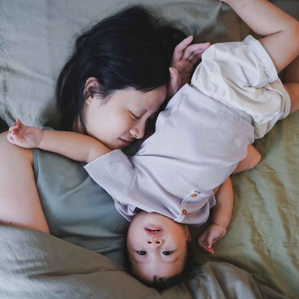 Mẹ đơn thân ôm con nhỏ và mỉm cười ấm áp thể hiện sự gắn kết và an toàn. (Ảnh được tạo bởi AI)